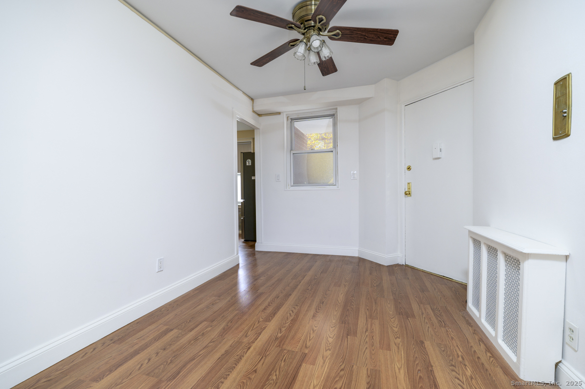 91 Strawberry Hill Avenue, Unit 331 Stamford, CT 06902 - Photo 5 of 19 an empty room with wooden floor fan and windows