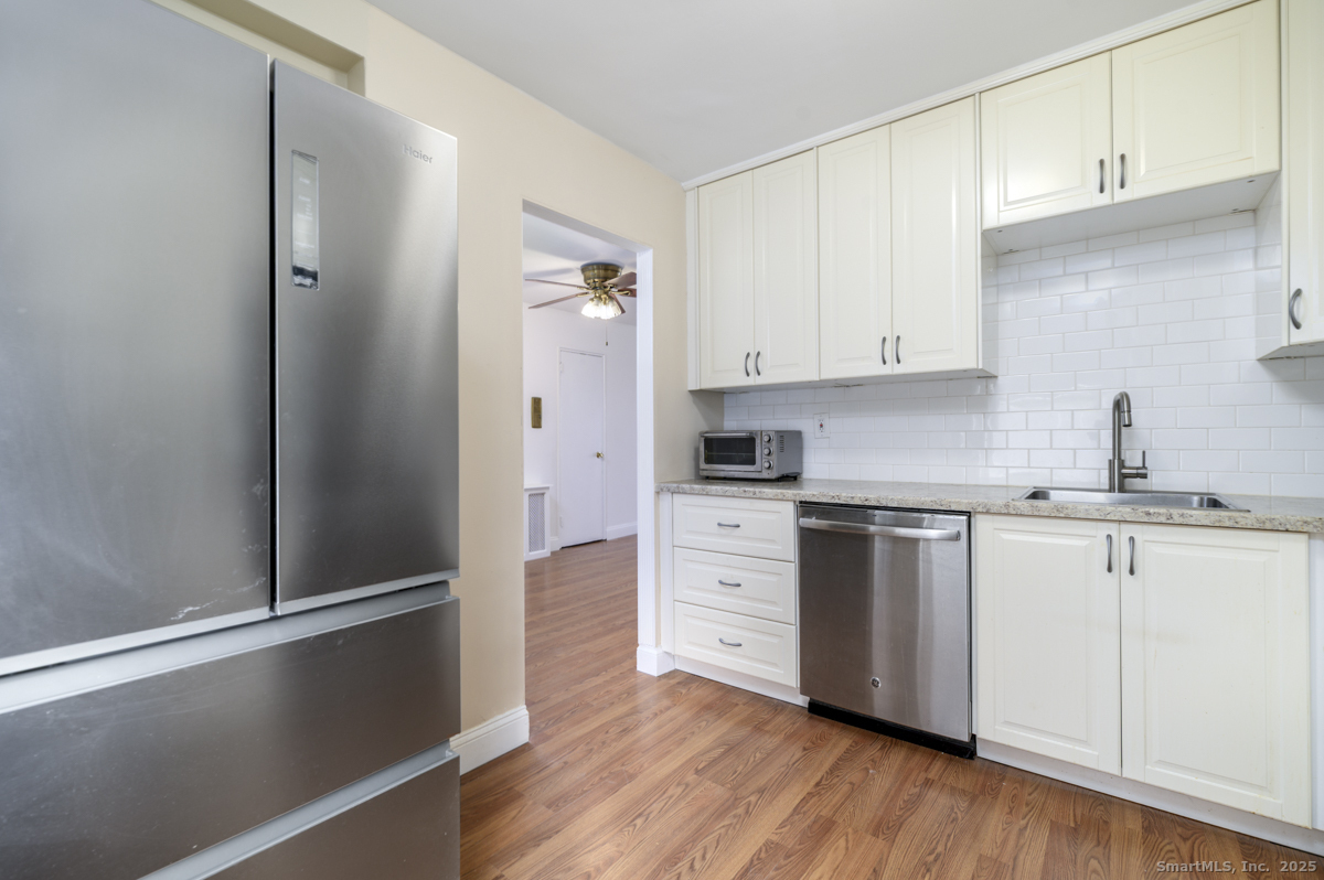 91 Strawberry Hill Avenue, Unit 331 Stamford, CT 06902 - Photo 8 of 19 a kitchen with granite countertop white cabinets and stainless steel appliances