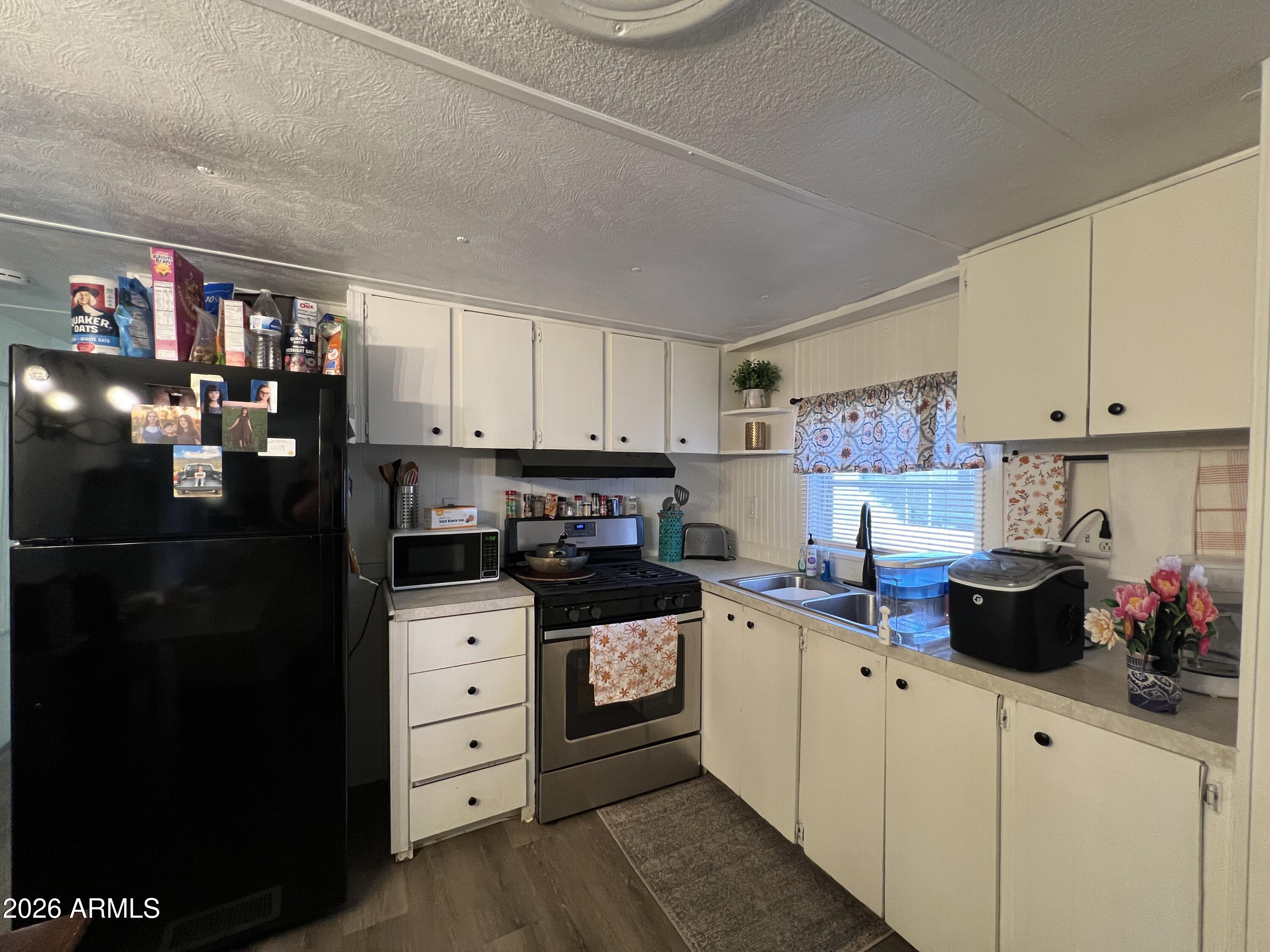 19225 North Cave Creek Road, Unit 40 Phoenix, AZ 85024 - Photo 11 of 21 a kitchen with stainless steel appliances a refrigerator sink and cabinets