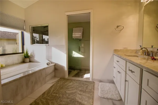 a spacious bathroom with a granite countertop sink and a mirror