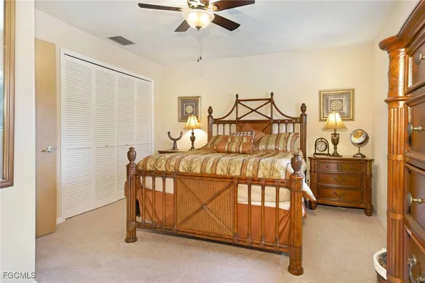 a bedroom with a bed and a ceiling fan
