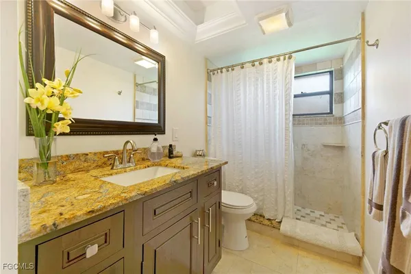 a bathroom with a granite countertop sink toilet and shower