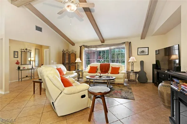 a living room with furniture a flat screen tv and a floor to ceiling window