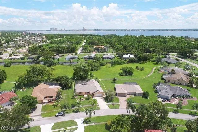 an aerial view of a city with lots of residential buildings ocean and mountain view in back