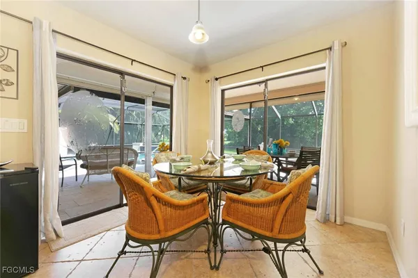 a dining room with furniture and large windows