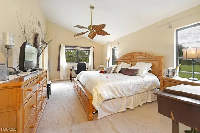 a bedroom with a bed flat screen tv and windows