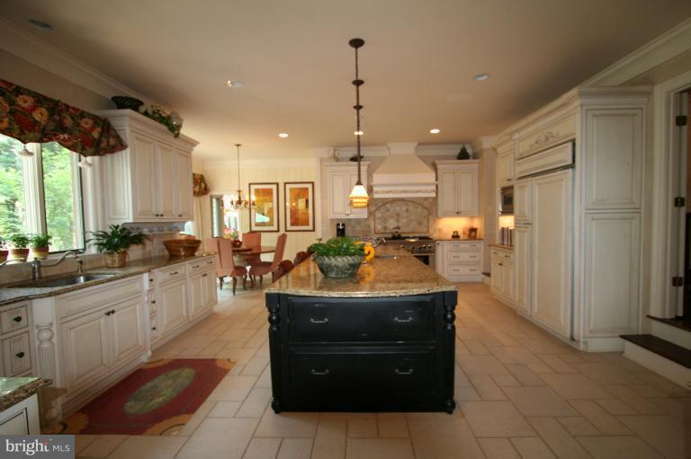 11114 Cripplegate Road Potomac, MD 20854 - Photo 13 of 30 a large kitchen with kitchen island granite countertop a sink counter space and stainless steel appliances