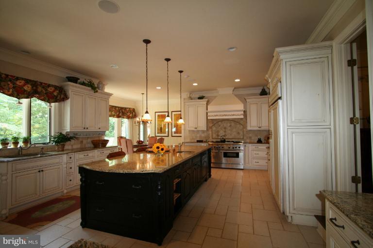 11114 Cripplegate Road Potomac, MD 20854 - Photo 19 of 30 a kitchen with kitchen island granite countertop a sink counter and refrigerator