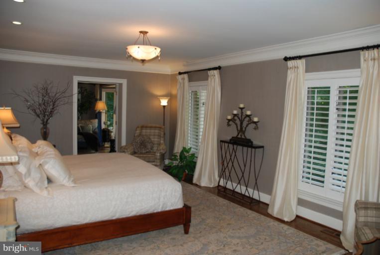11114 Cripplegate Road Potomac, MD 20854 - Photo 4 of 30 a bedroom with a bed and a chandelier