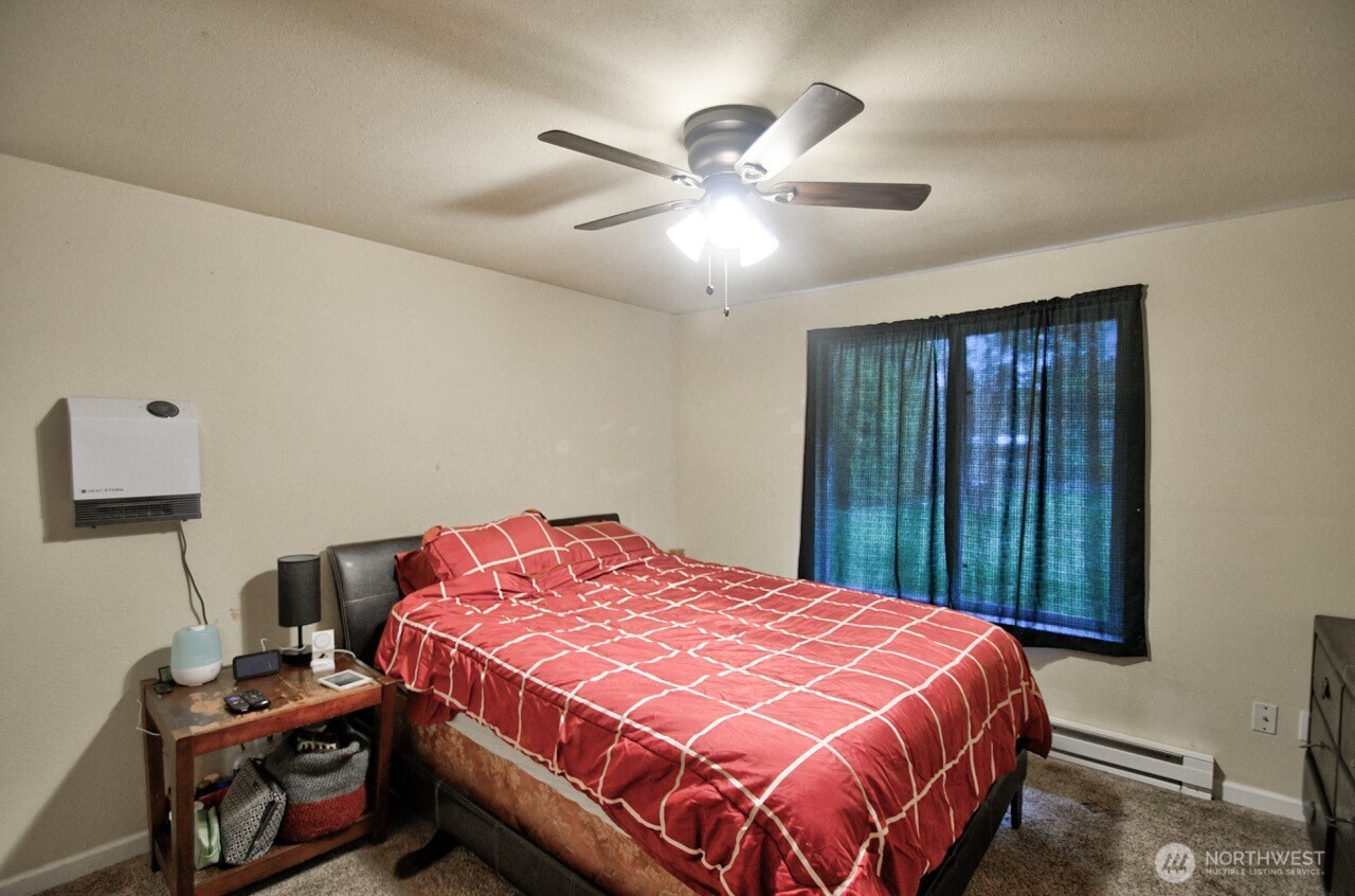 14939 Turner Road Southeast Rainier, WA 98576 - Photo 17 of 24 a bedroom with a bed and a chandelier