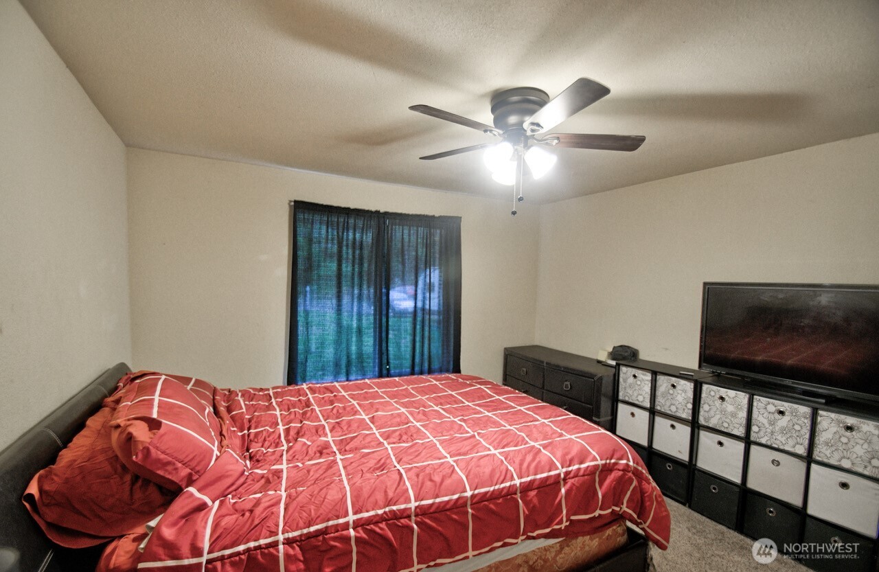 14939 Turner Road Southeast Rainier, WA 98576 - Photo 18 of 24 a bedroom with a bed and a flat screen tv