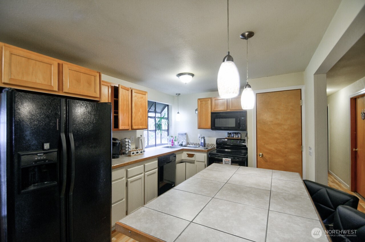 14939 Turner Road Southeast Rainier, WA 98576 - Photo 8 of 24 a kitchen with a sink stainless steel appliances a refrigerator and cabinets