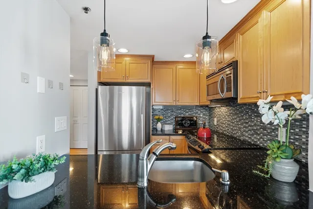 a kitchen with stainless steel appliances granite countertop a refrigerator and a sink