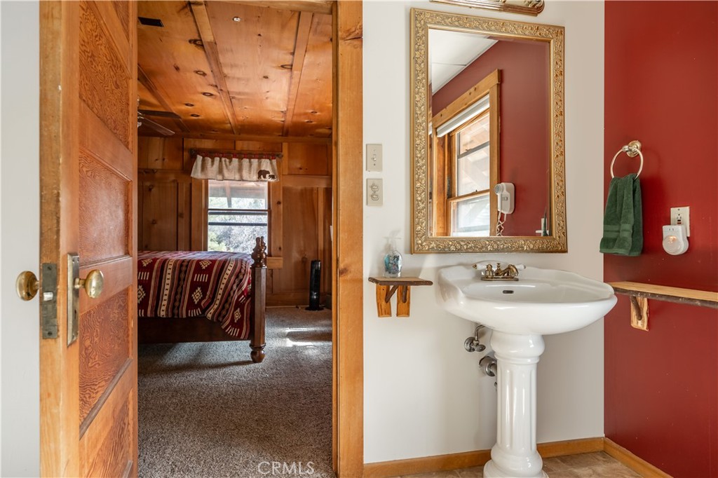 869 Knickerbocker Road Big Bear Lake, CA 92315 - Photo 24 of 50 a bathroom with a sink a mirror and next to a window