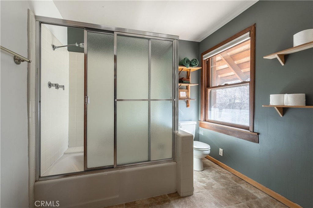 869 Knickerbocker Road Big Bear Lake, CA 92315 - Photo 30 of 50 a bathroom with a glass shower door and a window