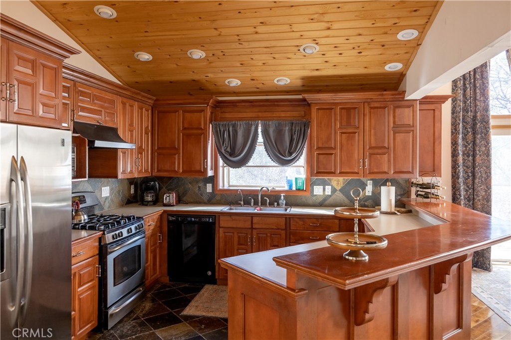 869 Knickerbocker Road Big Bear Lake, CA 92315 - Photo 43 of 50 a kitchen with stainless steel appliances a sink stove and cabinets