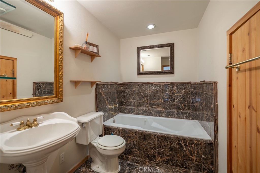 869 Knickerbocker Road Big Bear Lake, CA 92315 - Photo 46 of 50 a bathroom with a sink a toilet and a bathtub