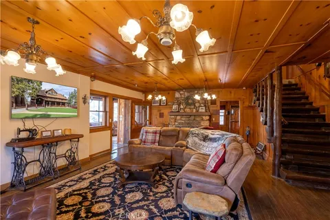 a living room with furniture a chandelier and a dining table