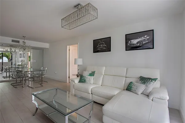 a living room with furniture and kitchen view