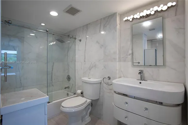 a bathroom with a sink toilet a mirror and shower