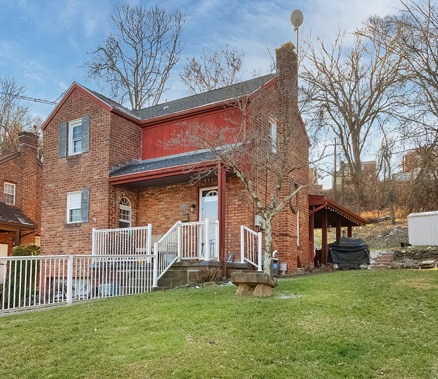 a view of a house with a yard and a wooden deck