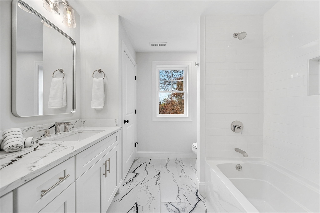 57 Raymond Street, Unit 2 Franklin, MA 02038 - Photo 31 of 41 a bathroom with a tub sink and mirror