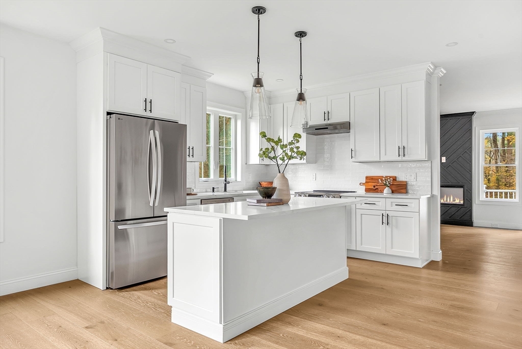 57 Raymond Street, Unit 2 Franklin, MA 02038 - Photo 5 of 41 a kitchen with stainless steel appliances granite countertop a refrigerator a sink dishwasher a stove and white cabinets with wooden floor