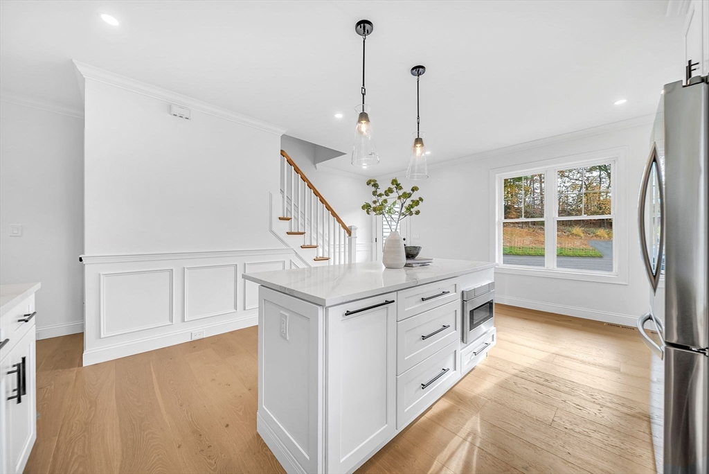 57 Raymond Street, Unit 2 Franklin, MA 02038 - Photo 6 of 41 a kitchen with stainless steel appliances granite countertop a stove and a chandelier