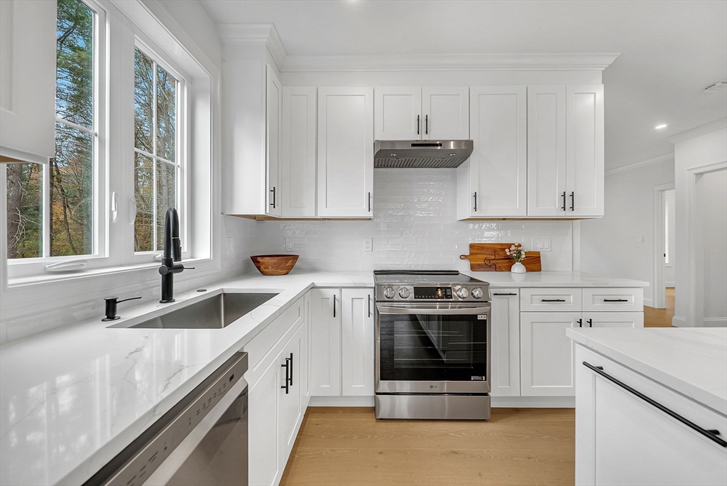 57 Raymond Street, Unit 2 Franklin, MA 02038 - Photo 7 of 41 a kitchen with granite countertop white cabinets and white stainless steel appliances