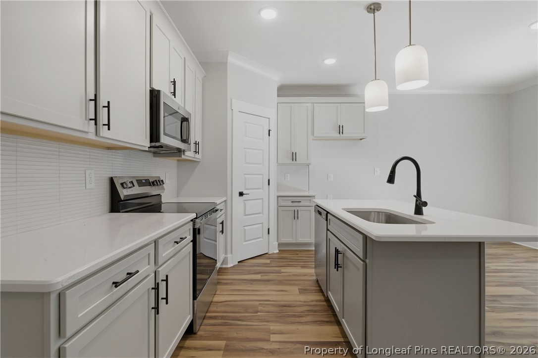 3931 Hamilton Street Hope Mills, NC 28348 - Photo 22 of 50 a kitchen with white cabinets stainless steel appliances and a sink