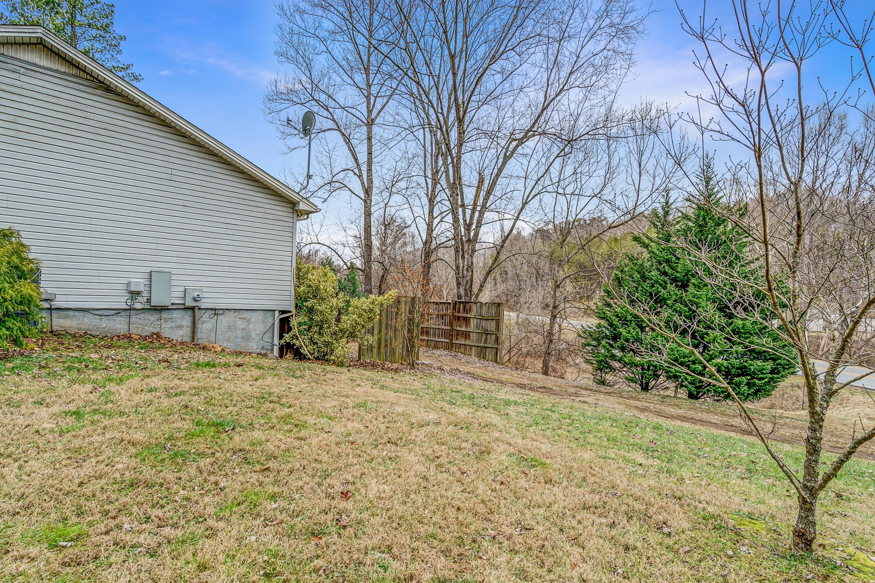 6071 Goodview Road Goodview, VA 24095 - Photo 5 of 44 a backyard of a house with large trees and brick walls