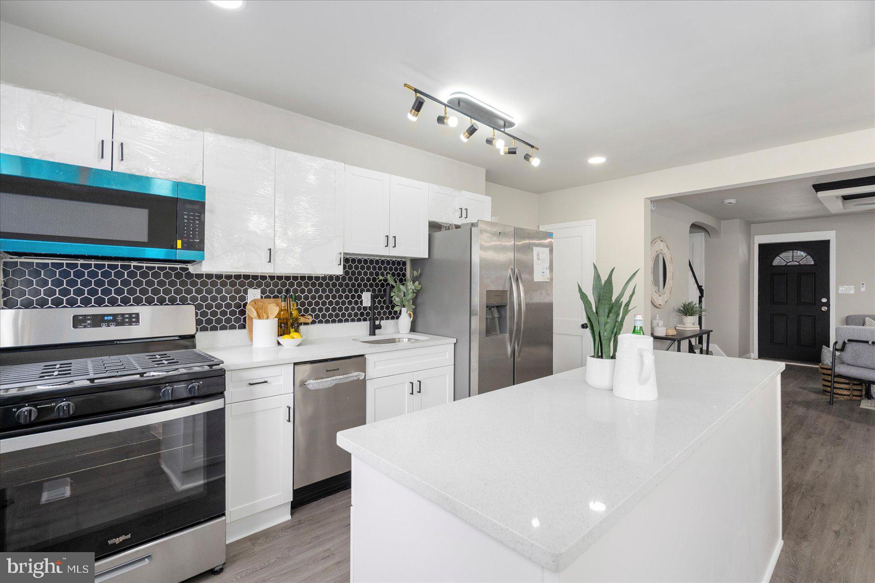 1020 Wicklow Road Baltimore, MD 21229 - Photo 12 of 44 a kitchen with stainless steel appliances a stove a sink dishwasher a refrigerator white cabinets with wooden floor