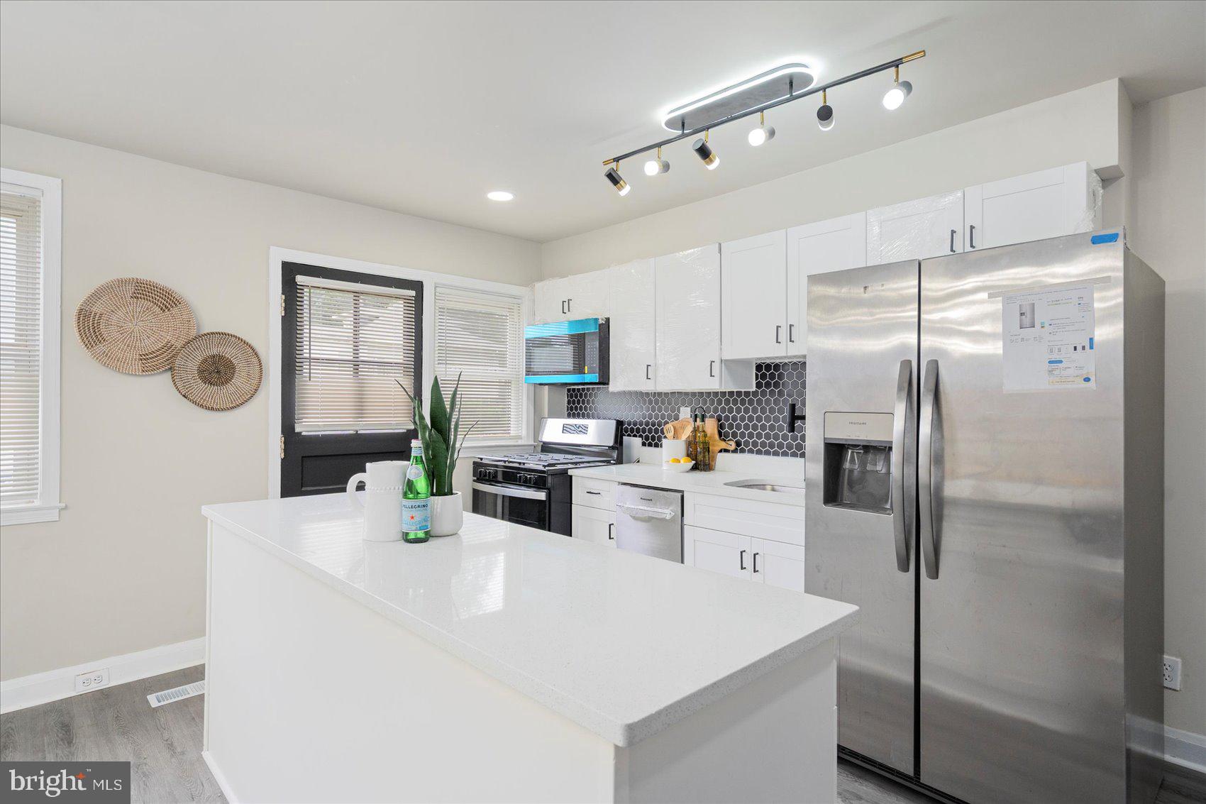 1020 Wicklow Road Baltimore, MD 21229 - Photo 17 of 44 a kitchen with white cabinets and stainless steel appliances