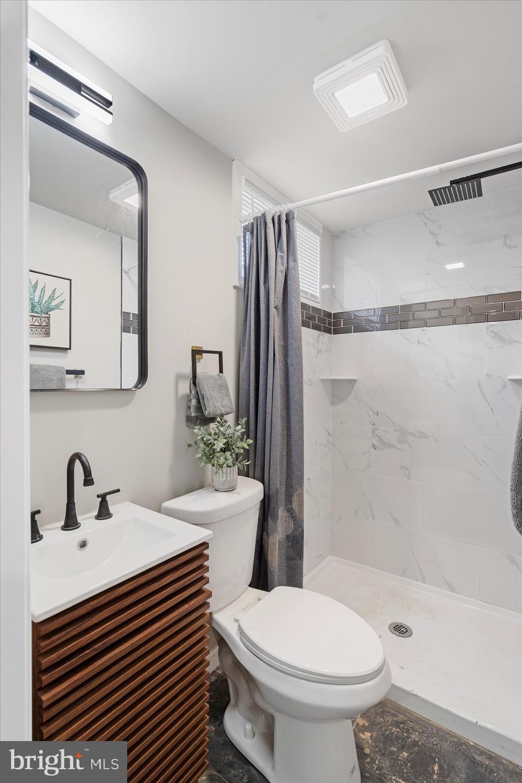 1020 Wicklow Road Baltimore, MD 21229 - Photo 36 of 44 a bathroom with a sink toilet a mirror and shower