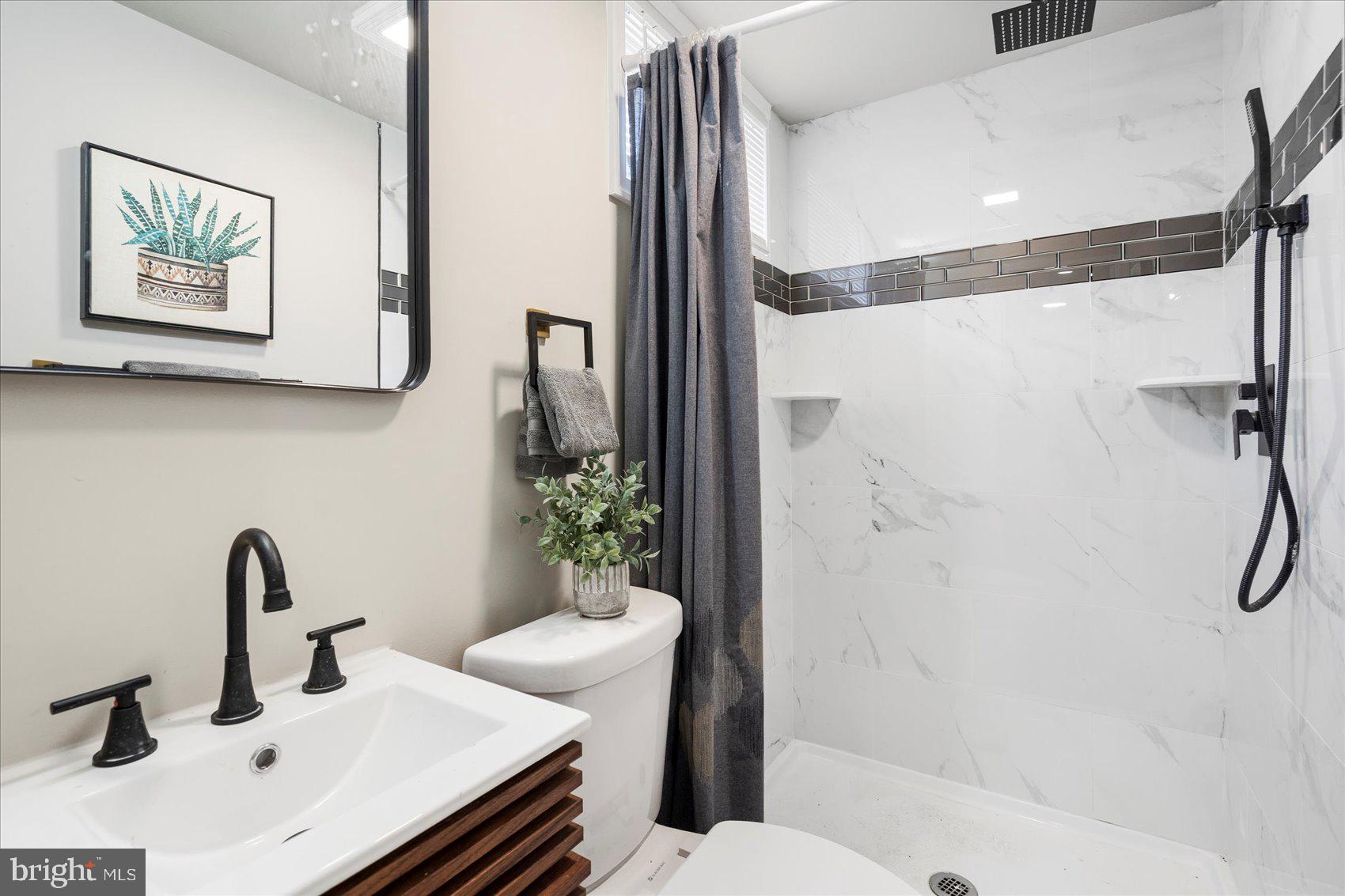 1020 Wicklow Road Baltimore, MD 21229 - Photo 37 of 44 a bathroom with a sink and mirror with toilet