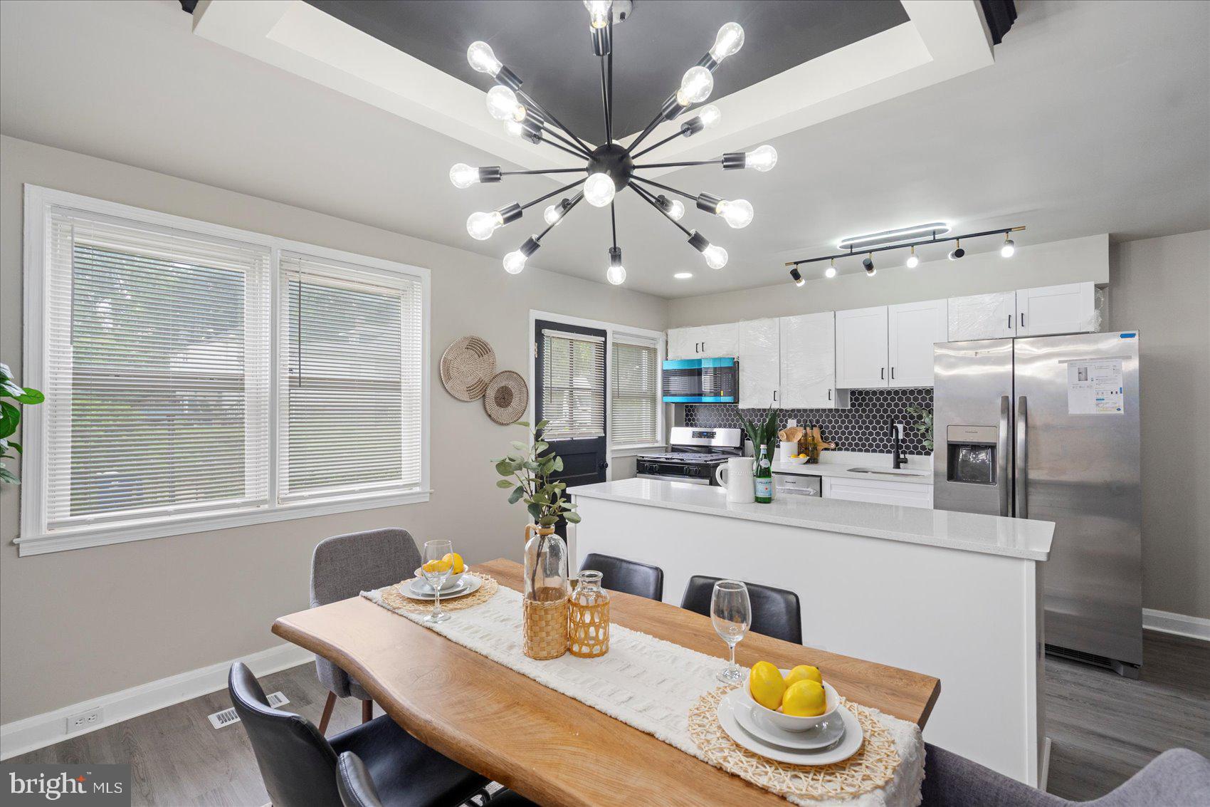 1020 Wicklow Road Baltimore, MD 21229 - Photo 9 of 44 a kitchen with a dining table chairs and white cabinets