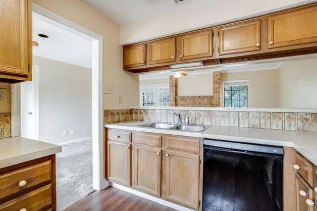 a kitchen with cabinets stainless steel appliances and a wooden floor