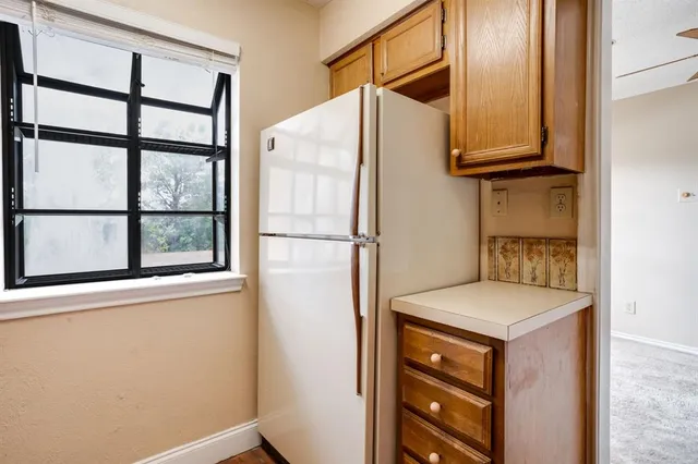 a kitchen with stainless steel appliances granite countertop a refrigerator and a window