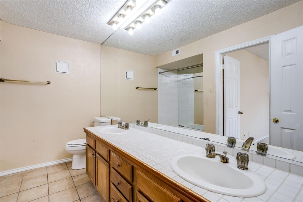 16301 Ledgemont Lane, Unit 267 Addison, TX 75001 - Photo 19 of 25 a bathroom with a sink double vanity and a toilet