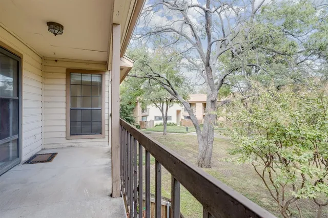 a view of balcony with wooden floor and fence