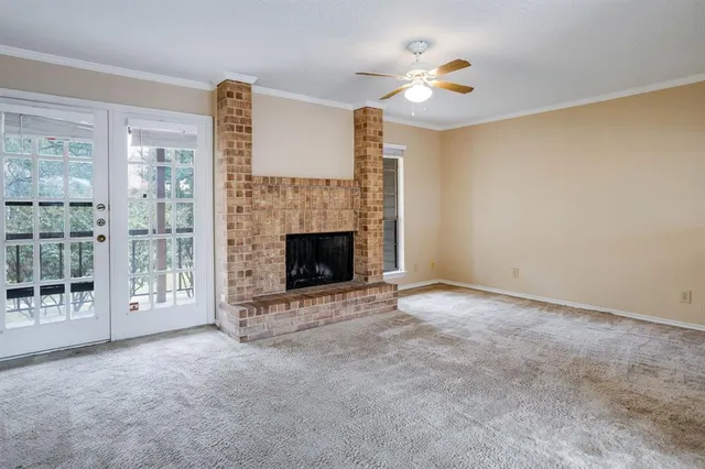 a view of an empty room with a fireplace and a window