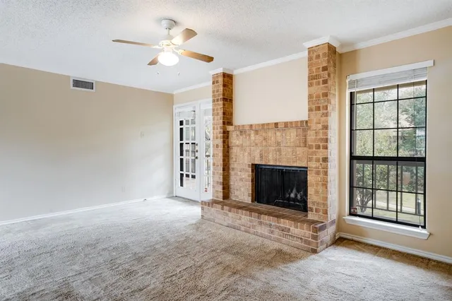 a view of a livingroom with a fireplace and a ceiling fan