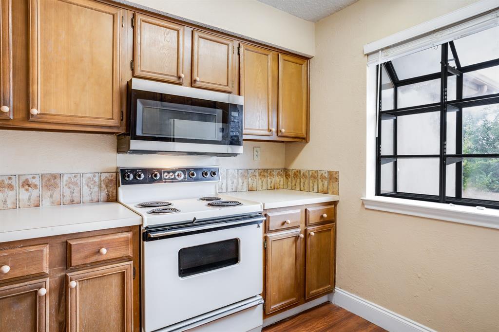 16301 Ledgemont Lane, Unit 267 Addison, TX 75001 - Photo 9 of 25 a kitchen with granite countertop cabinets stainless steel appliances and a window