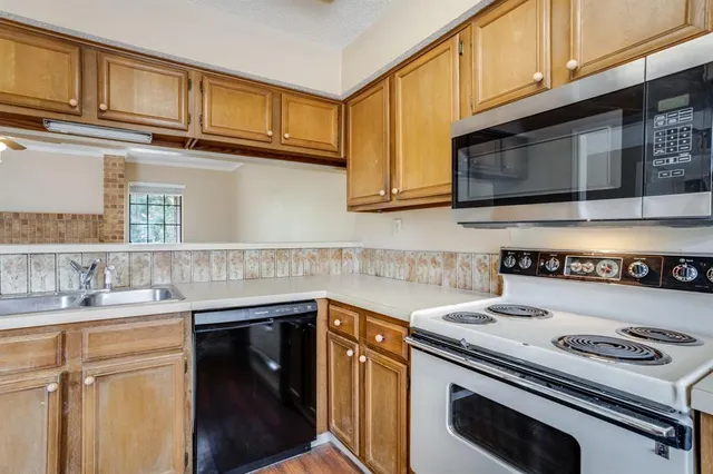 a kitchen with stainless steel appliances granite countertop a sink stove and microwave