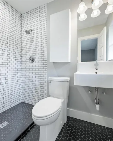 an empty room with wooden floor chandelier fan and windows