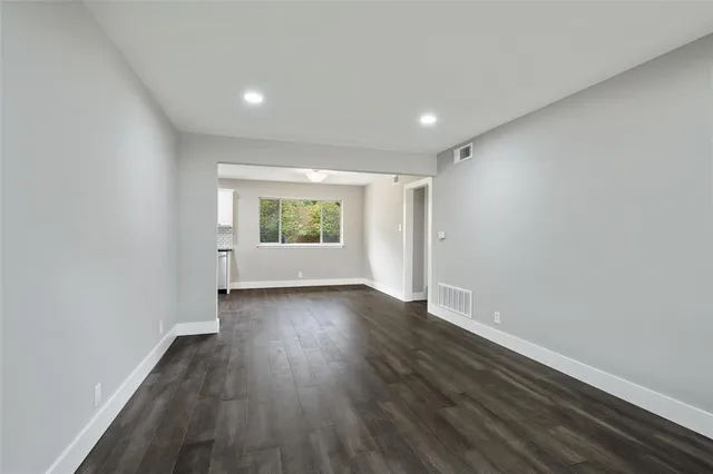 a open kitchen with white cabinets and wooden floor