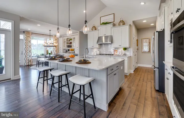 a kitchen with a table chairs stove and wooden floor