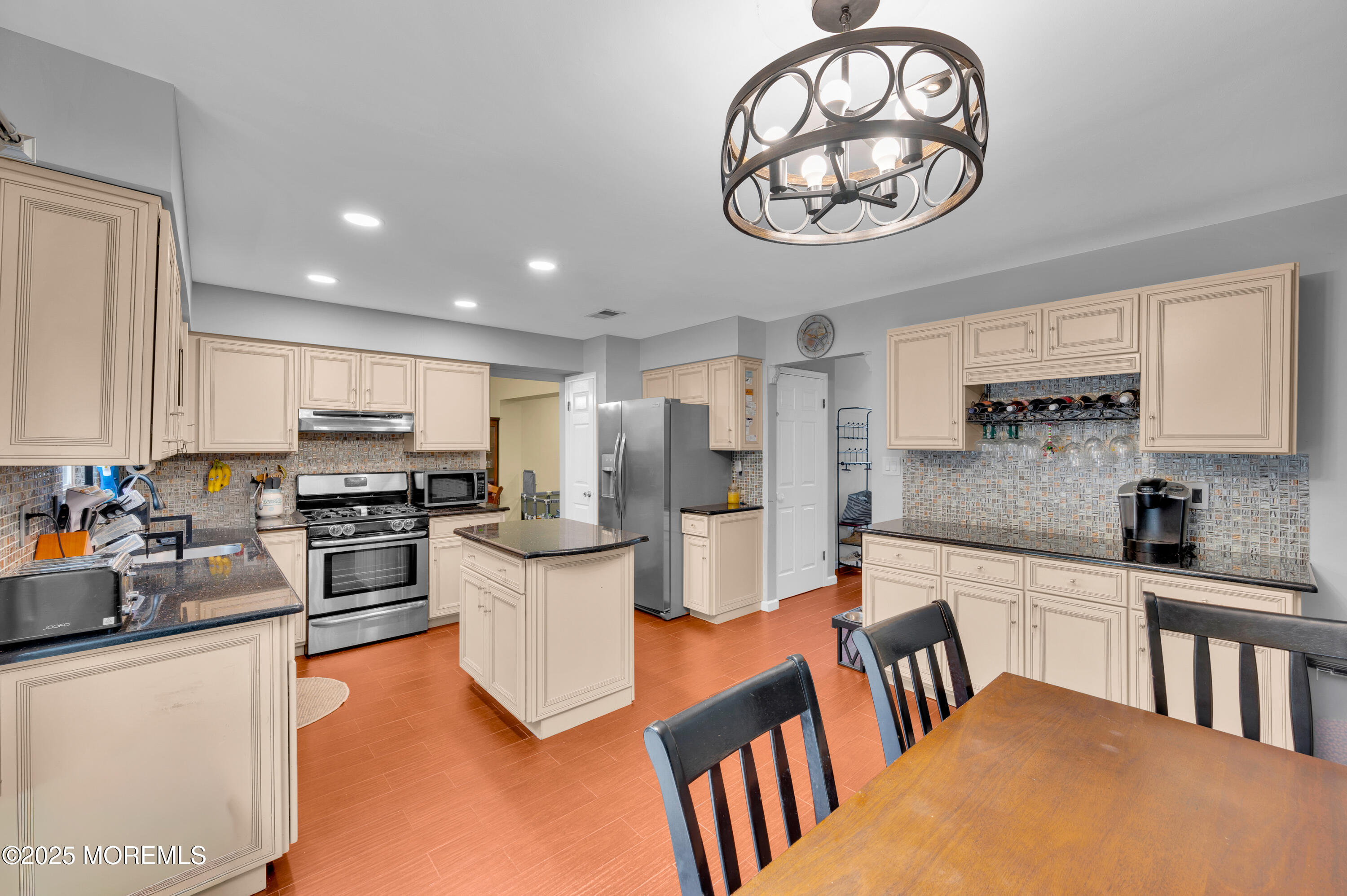 76 Diamond Lane Howell, NJ 07731 - Photo 15 of 36 a kitchen with stainless steel appliances granite countertop a stove top oven a sink a dining table and chairs