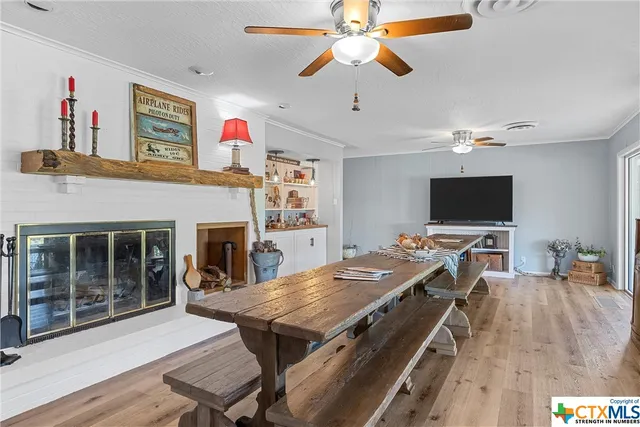a room with table chairs and book shelves