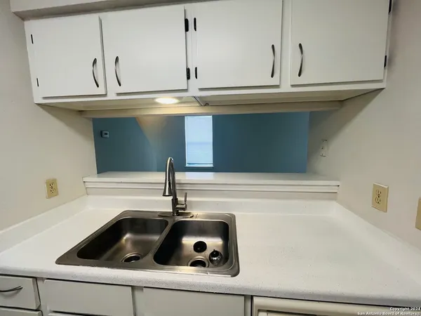 a kitchen with a sink cabinets and appliances